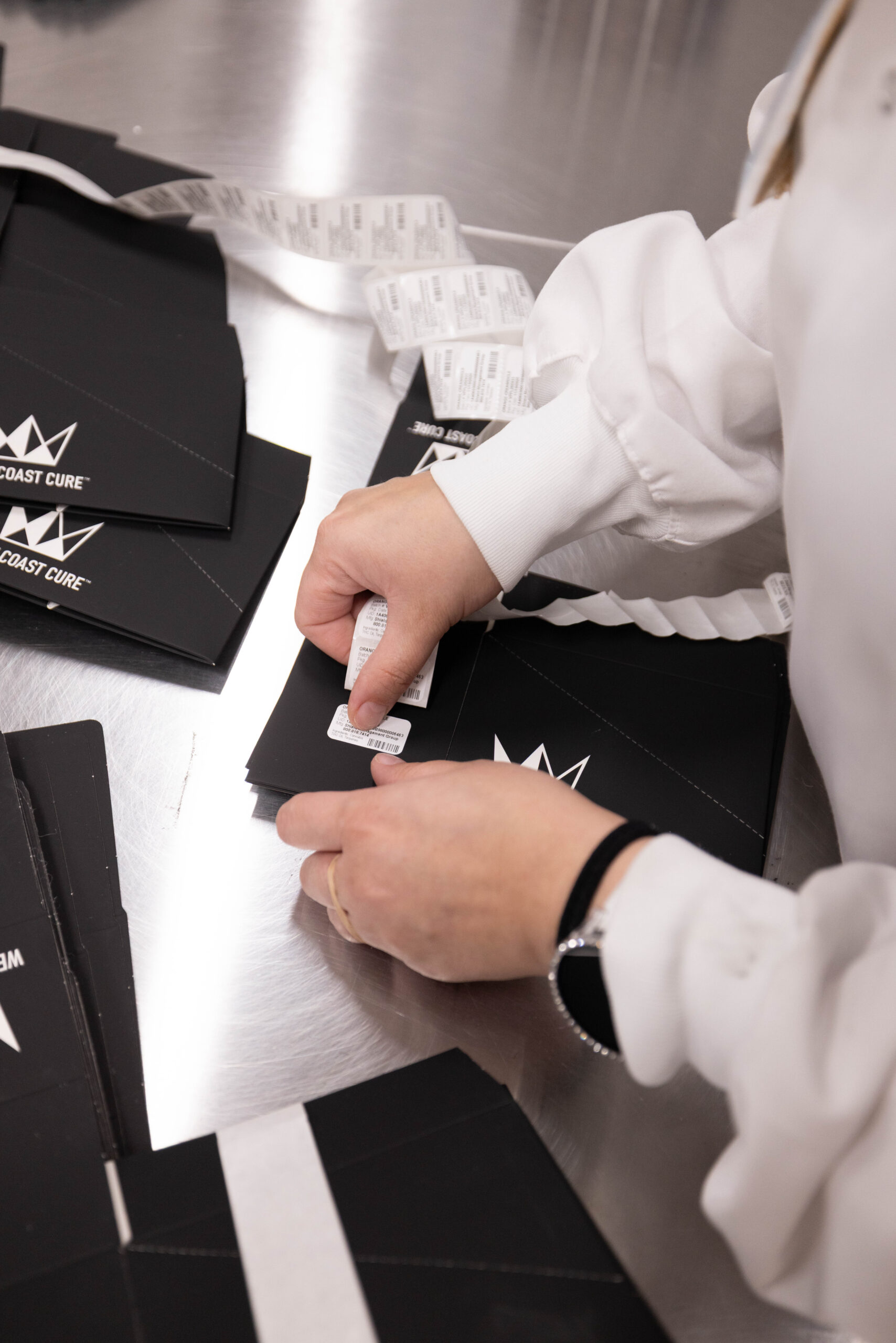 Technician applying compliance labels to branded vape packaging